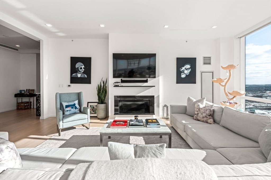 1 Franklin Street, Unit 5002 Boston, MA 02110 - Photo 4 of 40 a living room with furniture a flat screen tv and a fireplace