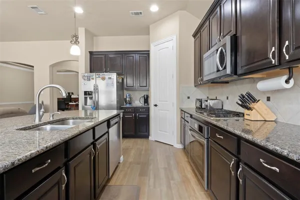 a kitchen with stainless steel appliances granite countertop a sink stove and refrigerator
