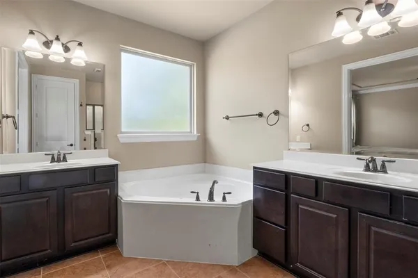 a bathroom with a tub sink and mirror