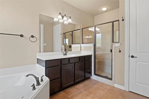 a spacious bathroom with a double vanity sink a large mirror and shower