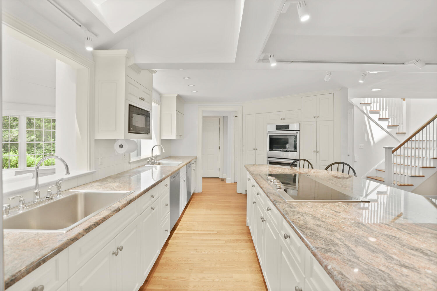 216 Turtle Back Road New Canaan, CT 06840 - Photo 11 of 38 a large white kitchen with stainless steel appliances granite countertop a sink and white cabinets
