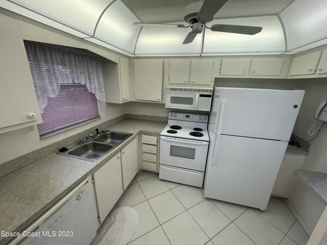 a kitchen with white cabinets and white appliances
