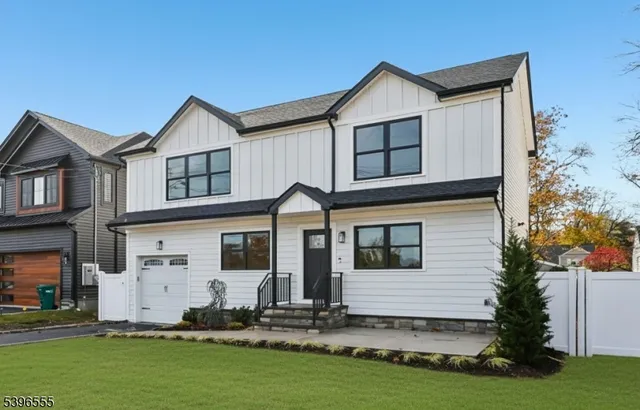 a view of a white house with yard in front of it