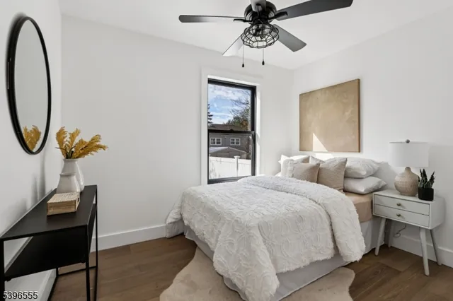a bedroom with a bed a mirror on desk and chair