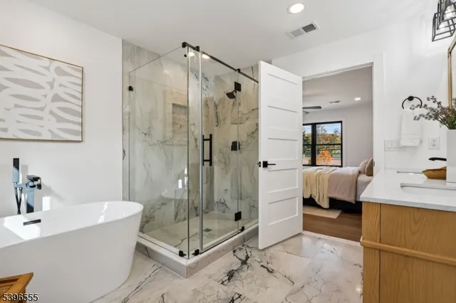 a bathroom with a tub shower sink and mirror