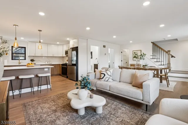 a living room with stainless steel appliances kitchen island furniture and a view of kitchen