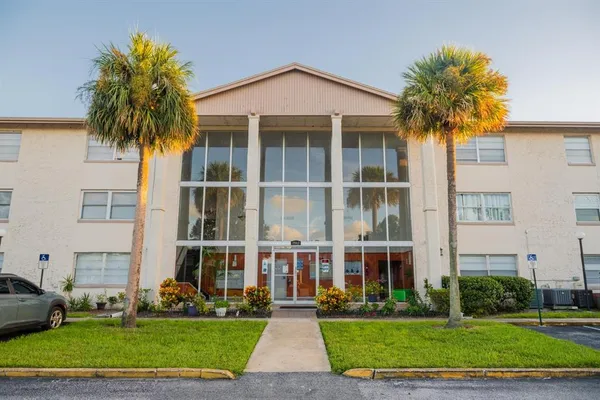 a front view of multi story residential apartment building with yard and green space