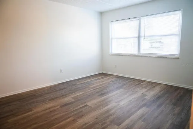 a view of an empty room with wooden floor