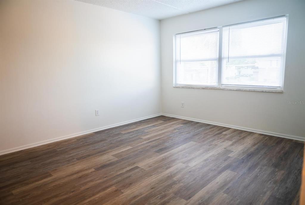 1902 Honour Road, Unit 23 Orlando, FL 32839 - Photo 12 of 19 an empty room with wooden floor and windows