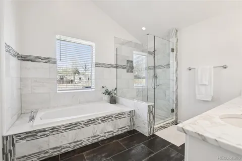 a spacious bathroom with a granite countertop tub sink and shower