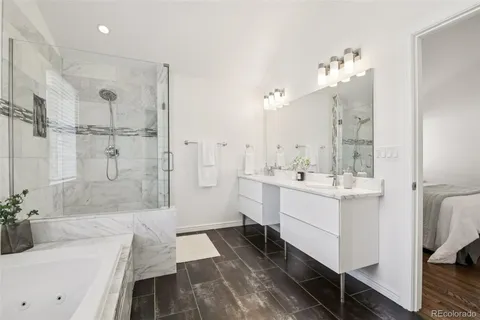 a bathroom with a double vanity sink a mirror a bathtub and shower