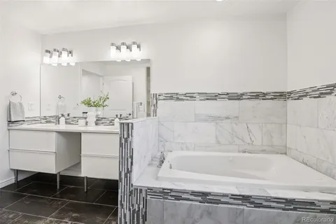 a bathroom with a bathtub sink and mirror