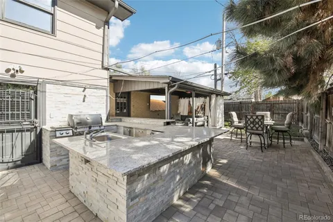 a view of a patio with table and chairs with wooden floor and fence