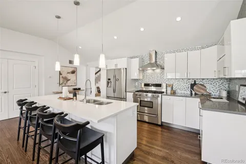 a kitchen with stainless steel appliances kitchen island granite countertop a dining table and chairs