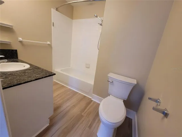 a bathroom with a granite countertop toilet and a sink