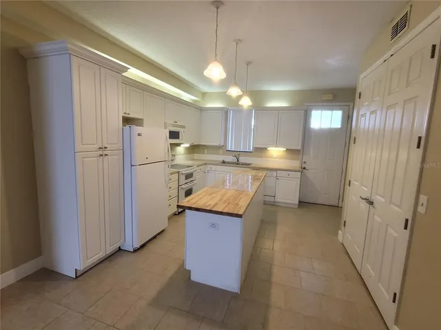 a kitchen with refrigerator and cabinets