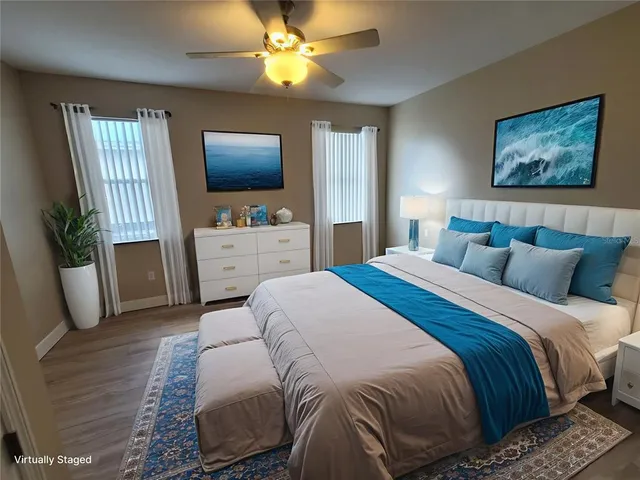 a bedroom with a bed a couch and a flat tv screen