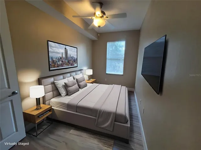 a bedroom with bed tv and window