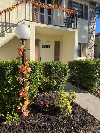 a front view of a house with a yard and fountain