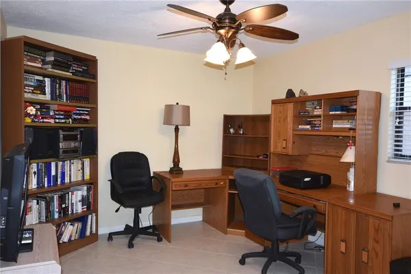 a view of a workspace with furniture and a bookshelf