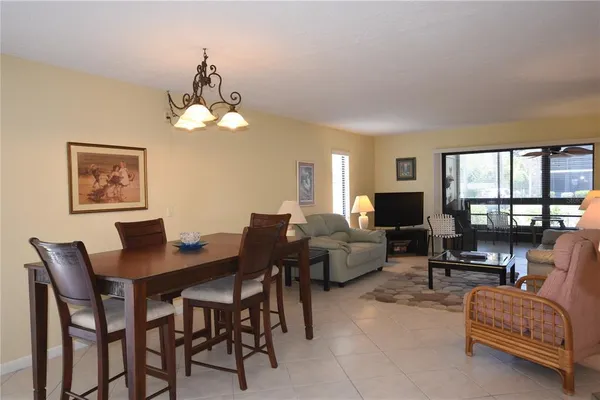 a living room with furniture a chandelier and a table