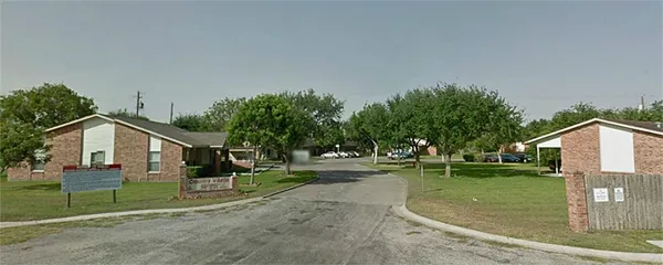 a view of a house with a big yard and large trees
