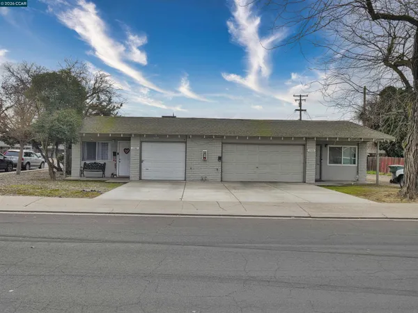 a front view of a house with a yard garage and outdoor seating