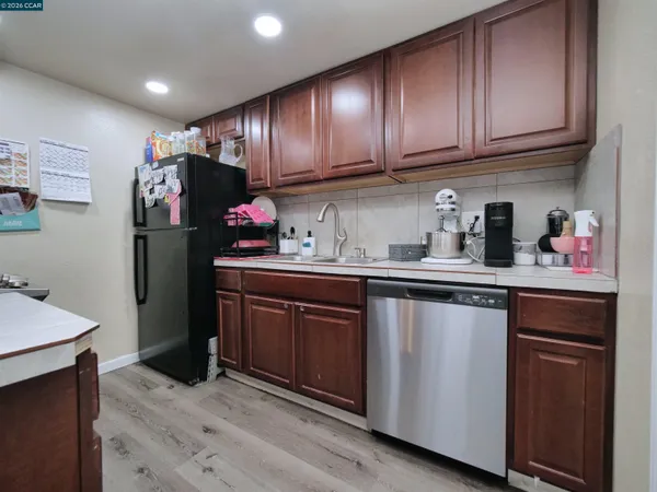 a kitchen with refrigerator cabinets and wooden floor
