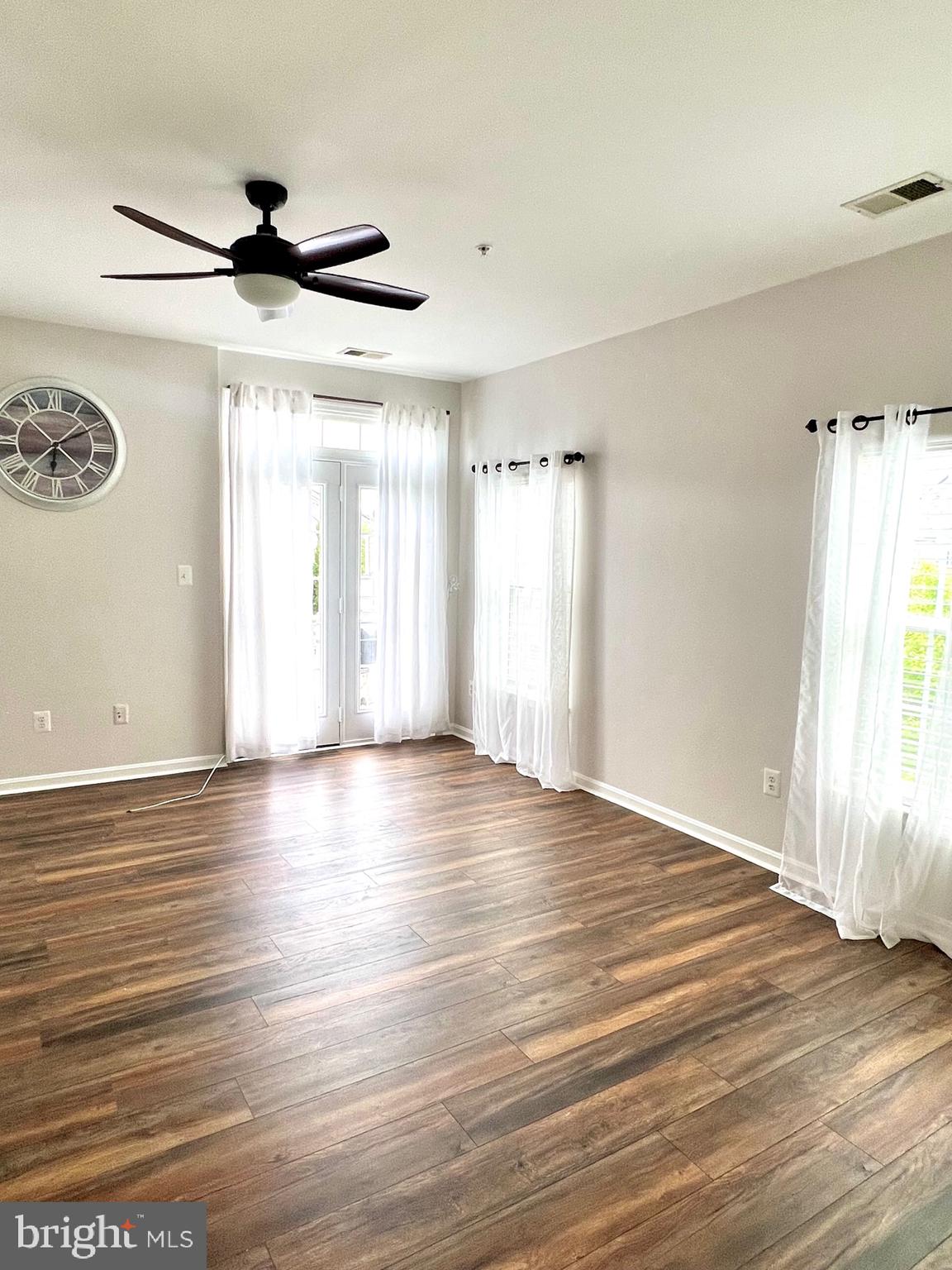 14468 Village High Street, Unit 148 Gainesville, VA 20155 - Photo 7 of 14 a view of an empty room with wooden floor and a window