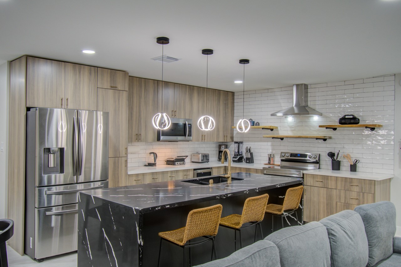 5539 Edith Street Houston, TX 77081 - Photo 14 of 50 a kitchen with stainless steel appliances granite countertop a sink a stove a refrigerator cabinets and chairs