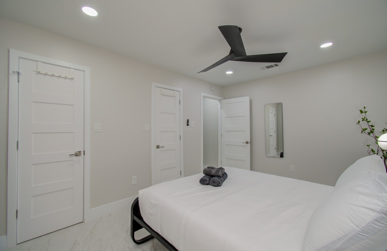 5539 Edith Street Houston, TX 77081 - Photo 29 of 50 a bedroom with a bed and a chandelier