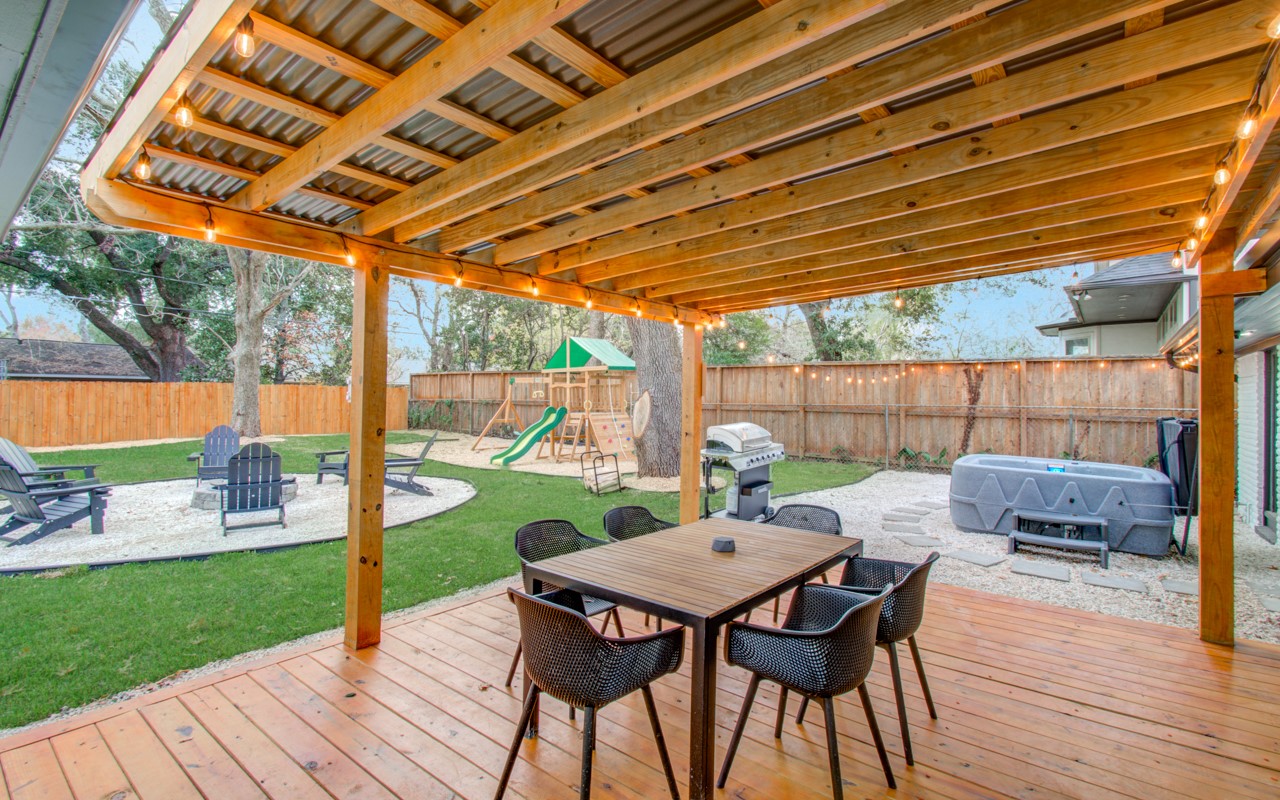 5539 Edith Street Houston, TX 77081 - Photo 37 of 50 a view of a patio with a table and chairs under an umbrella with a wooden floor