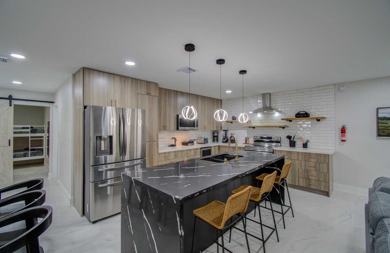 5539 Edith Street Houston, TX 77081 - Photo 9 of 50 a kitchen with stainless steel appliances granite countertop a kitchen island a stove and a refrigerator