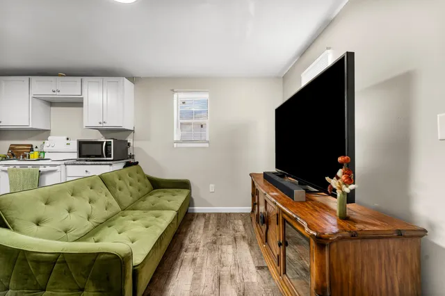 a living room with furniture and a wooden floor