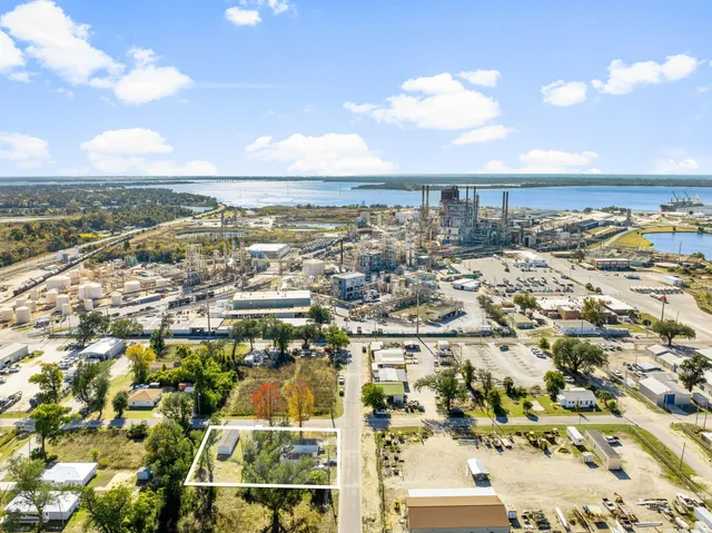 a swimming pool with yard and trees in the background