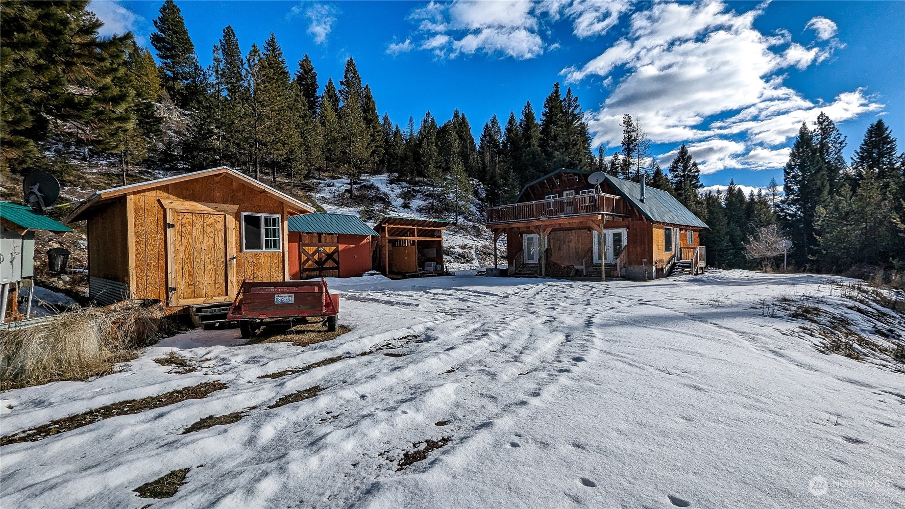 740 Cape Labelle Road Tonasket, WA 98855 - Photo 2 of 40 a front view of a house with a yard covered with snow and trees