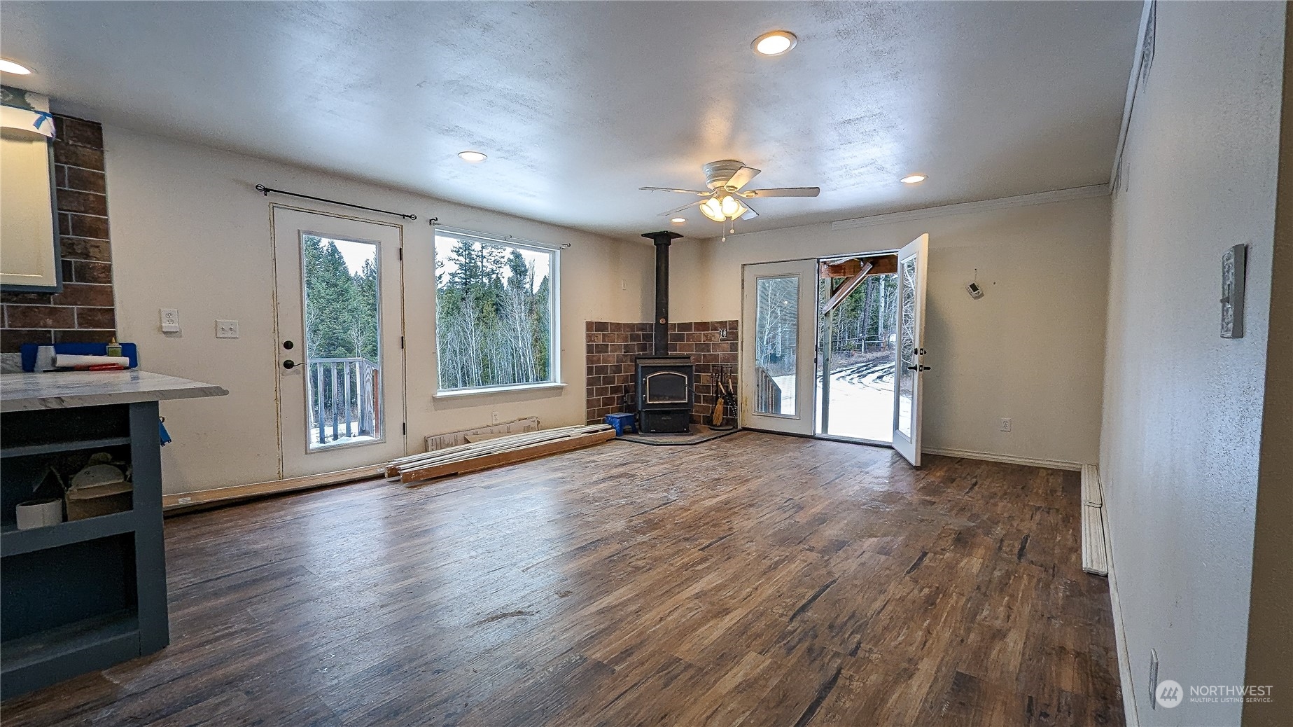 740 Cape Labelle Road Tonasket, WA 98855 - Photo 8 of 40 an empty room with wooden floor fireplace and windows