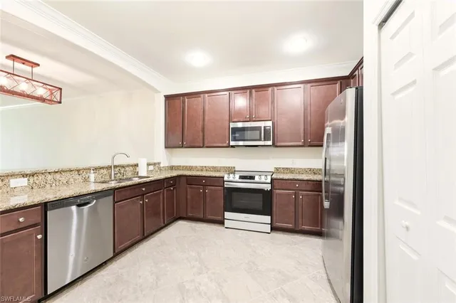 a kitchen with stainless steel appliances granite countertop a stove top oven a sink and dishwasher