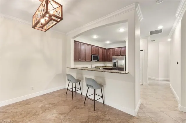 a kitchen with stainless steel appliances kitchen island granite countertop a refrigerator and a sink