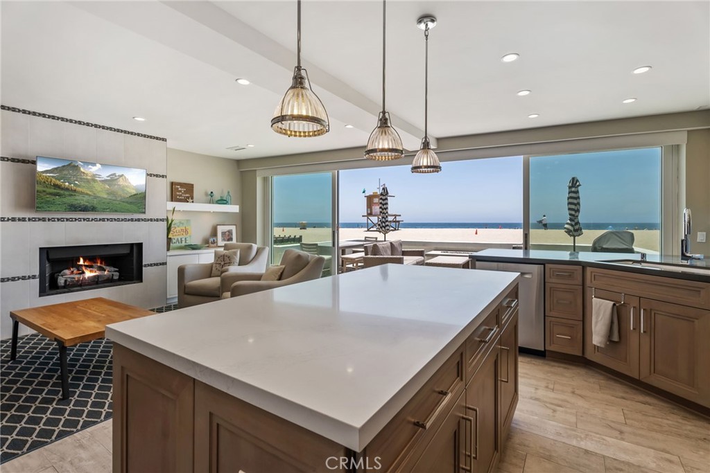 4403 Seashore Drive Newport Beach, CA 92663 - Photo 14 of 69 a kitchen with a stove a kitchen island a sink dishwasher a dining table and chairs with wooden floor