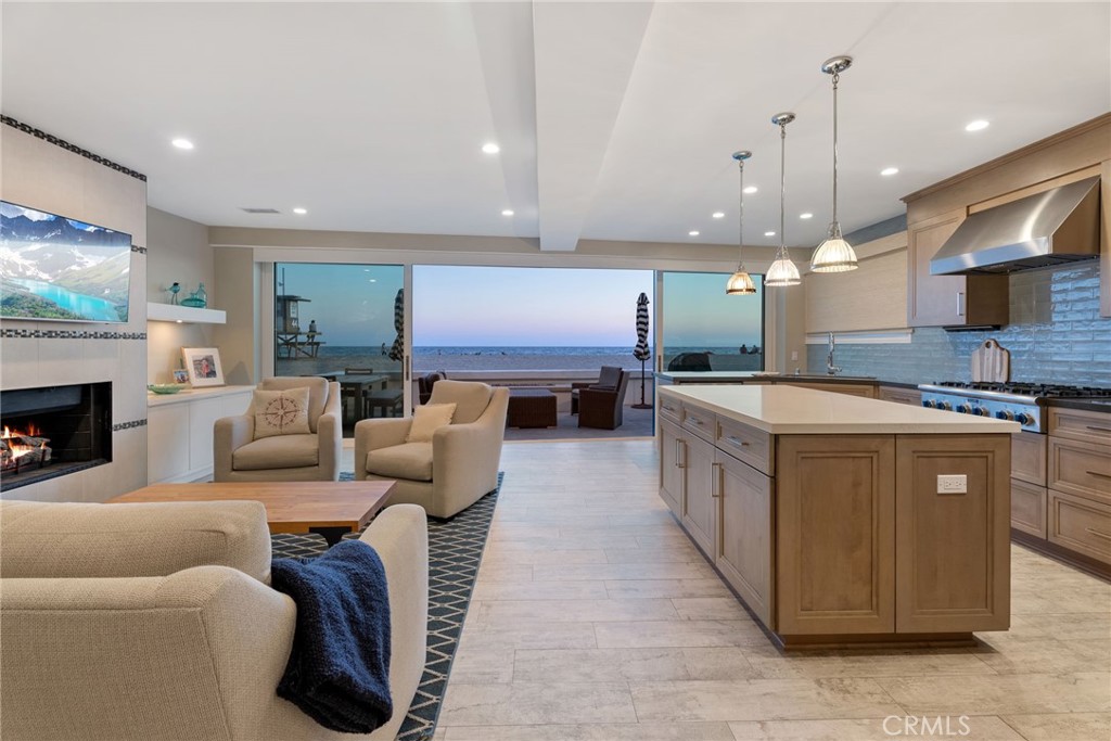 4403 Seashore Drive Newport Beach, CA 92663 - Photo 18 of 69 a large kitchen with stainless steel appliances kitchen island granite countertop a table chairs and a wooden floor