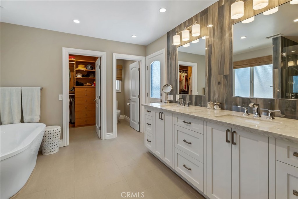 4403 Seashore Drive Newport Beach, CA 92663 - Photo 32 of 69 a spacious bathroom with a double vanity sink a large mirror and a bathtub