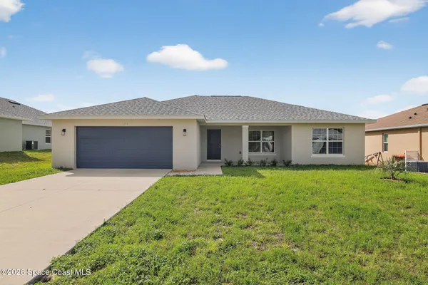 a yellow and red house sitting in middle of the grass