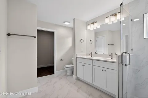 a bathroom with a double vanity sink mirror and toilet