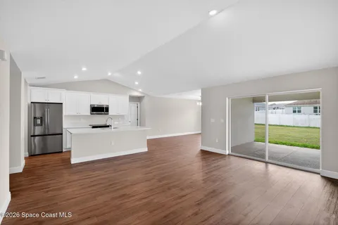 a view of kitchen with microwave and refrigerator