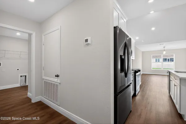 a view of a hallway with wooden floor and staircase
