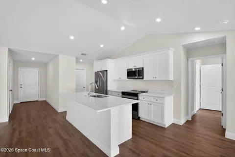 a kitchen with stainless steel appliances a stove top oven a sink and a refrigerator