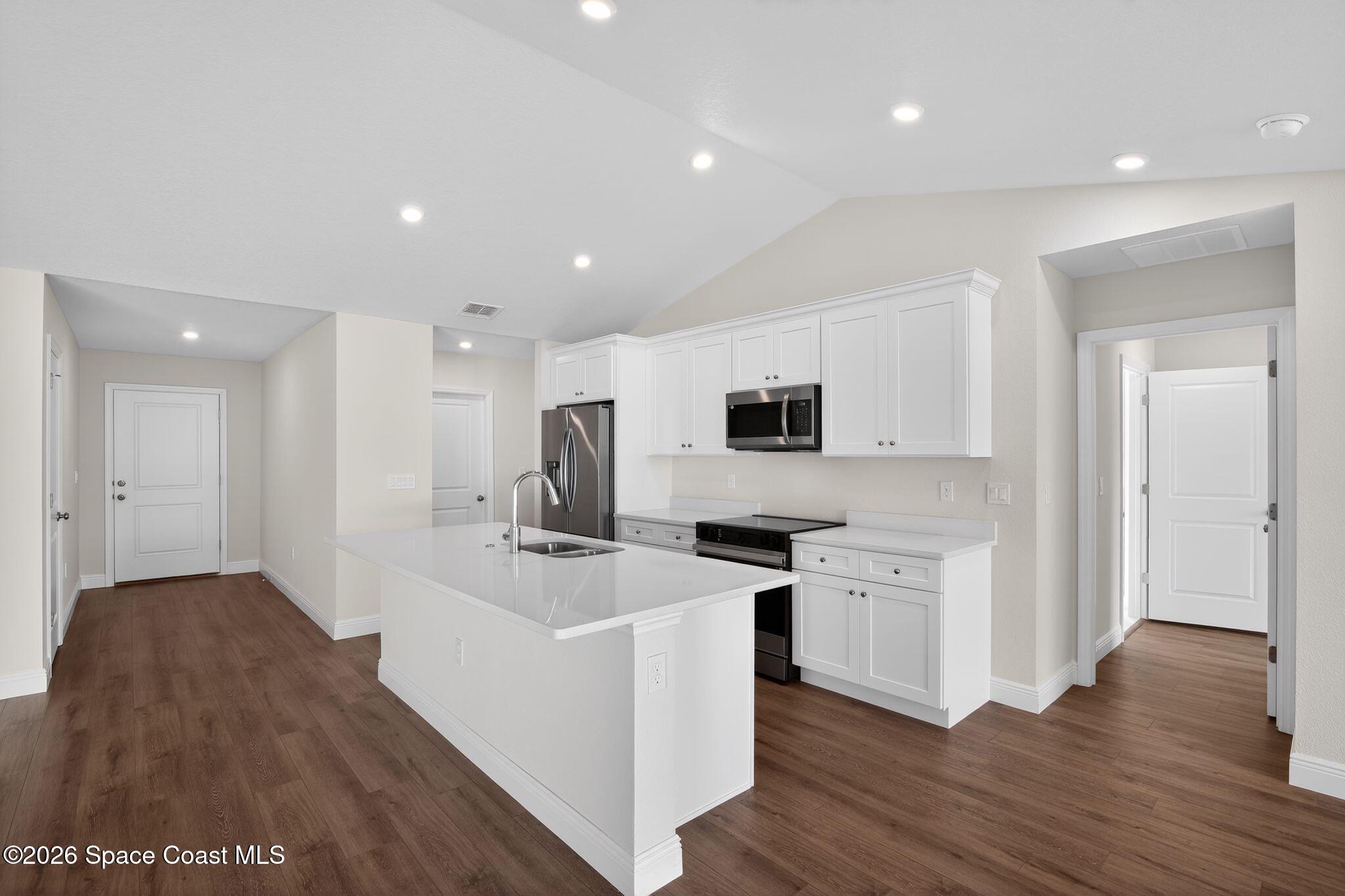 5294 Southeast 91st Street Ocala, FL 34480 - Photo 6 of 15 a kitchen with stainless steel appliances a stove top oven a sink and a refrigerator