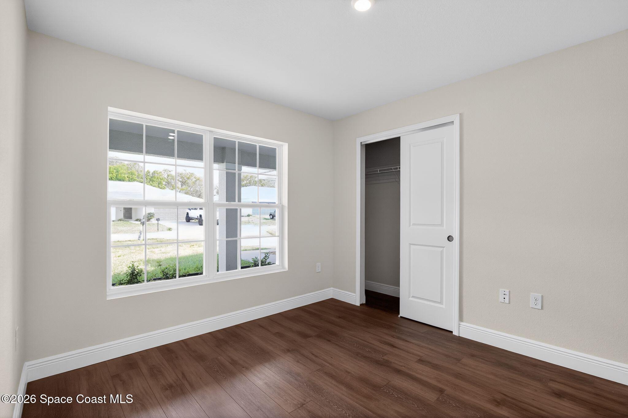 5294 Southeast 91st Street Ocala, FL 34480 - Photo 7 of 15 a view of an empty room with wooden floor and windows