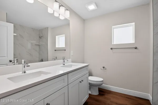 a bathroom with a granite countertop sink a toilet and a mirror